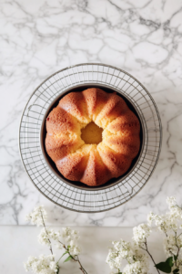 cooling-lemon-pound-cake-in-bundt-pan-on-white-marble