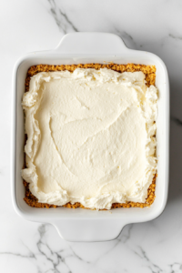 cream-cheese-layer-spread-on-graham-cracker-crust-in-ceramic-dish