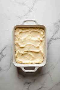 custard-layer-over-rhubarb-in-white-dish-with-oval-handles