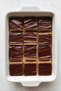 cut-peanut-butter-bars-in-white-dish-over-white-marble-surface