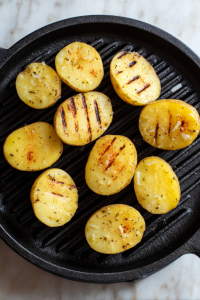 cut-side-potatoes-on-grill-pan-with-char-marks-white-marble