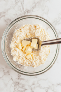 cutting-butter-into-flour-mixture-in-glass-bowl