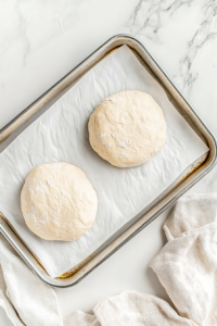 flattened-dough-discs-on-baking-sheet