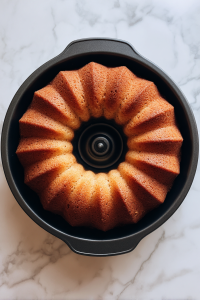 freshly-baked-pecan-praline-cake-in-black-bundt-pan-on-white-marble