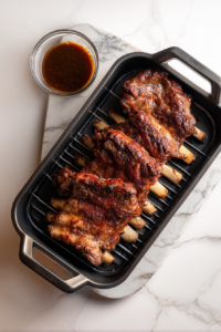 fully-cooked-smoked-ribs-in-black-smoker-on-white-marble