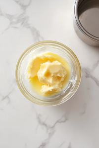 glass-bowl-of-melted-butter-on-white-marble-with-no-background-clutter