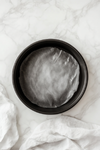 greased-round-pan-lined-with-parchment-paper-on-marble-top