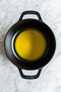 heating-olive-oil-in-black-dutch-oven-over-marble