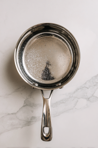 heating-vinegar-salt-sugar-water-in-silver-saucepan-to-make-pickling-brine