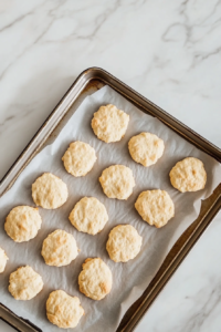 lancashire-biscuits-baking-on-baking-sheet-in-oven-on-white-marble-background