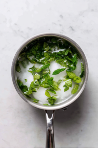 mint-syrup-prep-in-stainless-saucepan-on-white-marble
