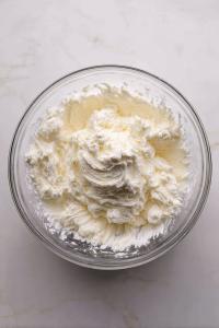 mixing-butter-sugar-cream-cheese-in-glass-bowl