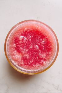 mixing-watermelon-puree-with-syrup-in-glass-bowl-on-marble