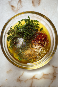 olive-oil-marinade-in-glass-bowl-on-white-marble