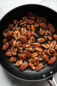 pecans-stirred-into-caramel-glaze-in-black-skillet