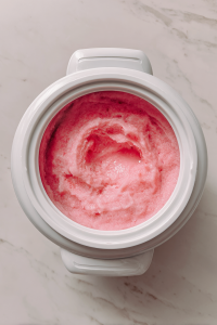 pouring-sorbet-mixture-into-white-ice-cream-maker-on-marble