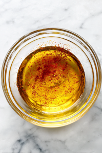 preparing-salad-dressing-in-clear-glass-bowl-on-white-marble