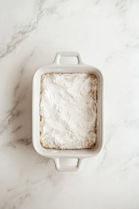pressing-shortbread-crust-into-rectangular-white-ceramic-dish