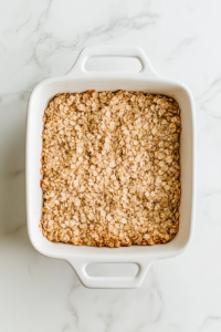 pressing-the-crumbles-mixture-on-the-bottom-of-the-baking-dish
