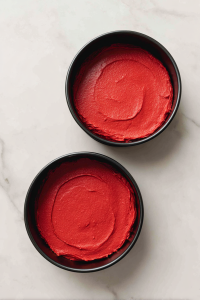 red-velvet-batter-in-black-springform-pans-on-marble-before-baking