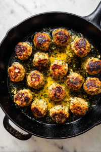 searing-greek-chicken-meatballs-in-black-cast-iron-skillet