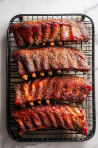 seasoned-ribs-on-black-smoker-rack-on-white-marble