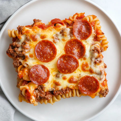 serving-a-square-slice-of-loaded-meat-lovers-pizza-casserole-on-a-matte-white-ceramic-plate