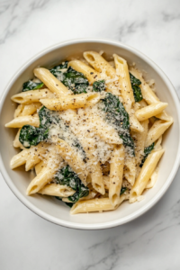 serving-creamy-protein-pasta-in-white-ceramic-bowl-with-parmesan-and-pepper