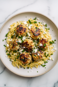serving-greek-meatballs-on-lemon-orzo-with-feta-and-parsley