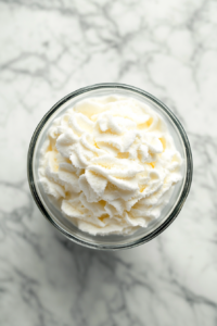 whipping-soft-peaks-of-cream-vanilla-and-sugar-in-glass-bowl