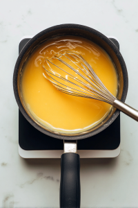 whisking-chicken-broth-into-roux-in-black-saucepan-2
