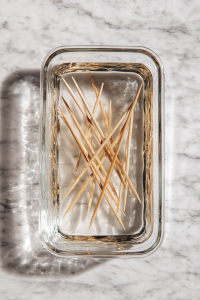 wooden-skewers-soaking-in-rectangular-glass-dish-on-white-marble