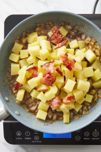 Add the sautéed onions and crumbled bacon